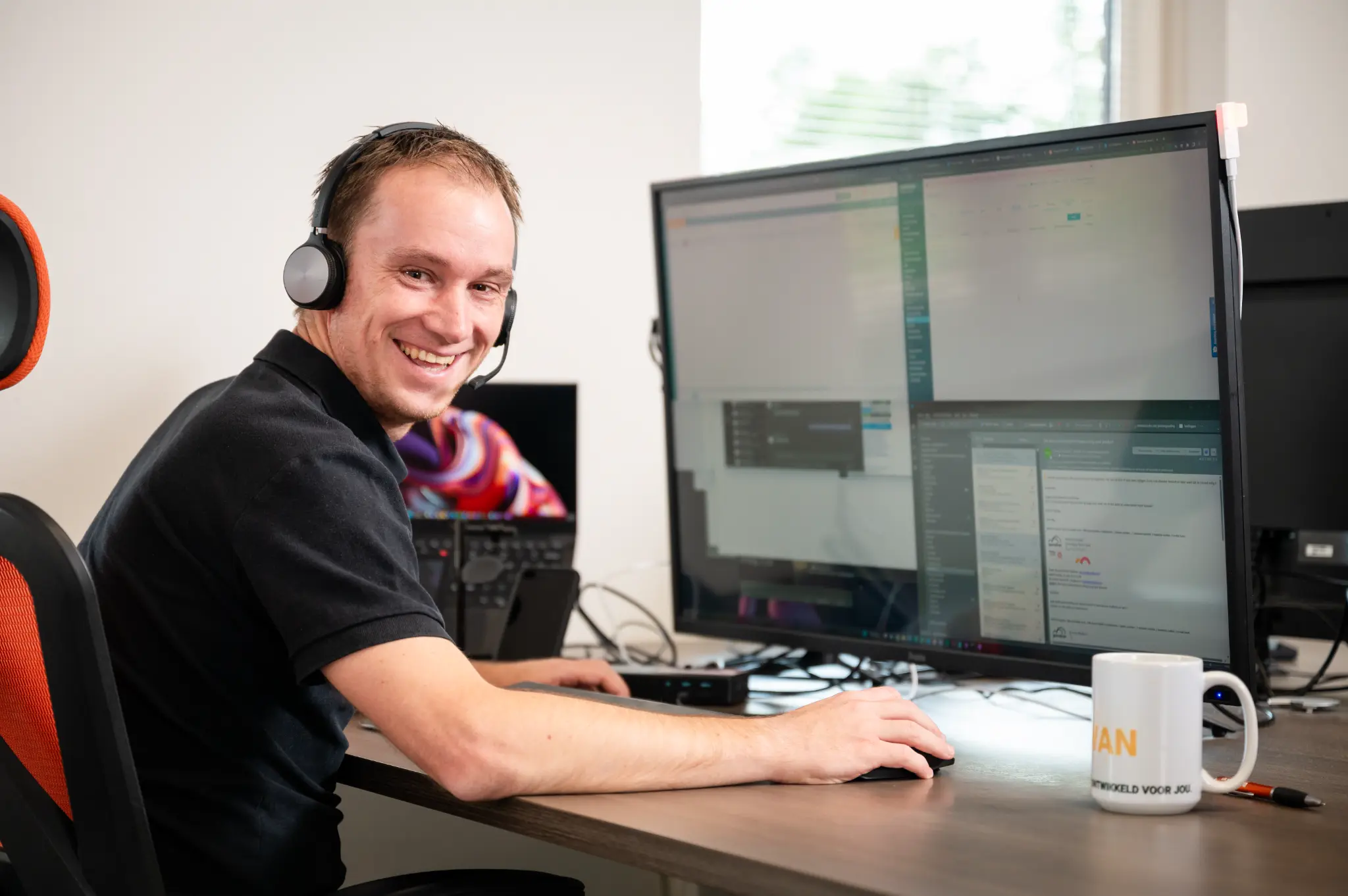 Daemen ICT-collega met headset zit klaar om een eerste ICT-vraag te bespreken.